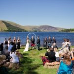 Wedding ceremony at St Mary's loch - photo of guests and couple during ceremony in front of loch and hills
