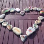 painted stones laid out in the shape of a heart